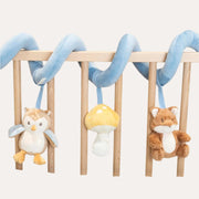 Little Dutch Forest Friends activity spiral wrapped around a rail, with hanging owl, mushroom and fox toys.