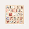 Wooden alphabet puzzle with colorful letters on a light beige background