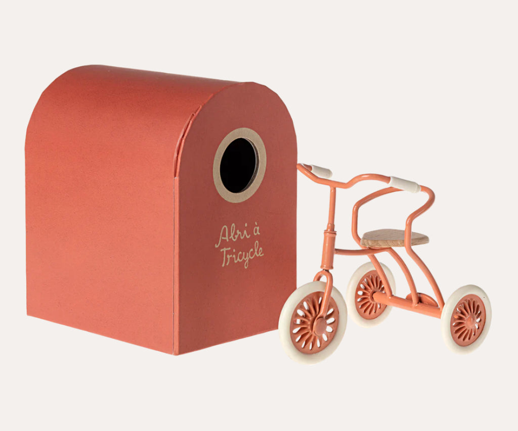 Red toy box with a small pink tricycle on a white background