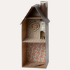 Wooden birdhouse with floral interior and decorative elements on a white background