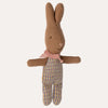 Knitted toy rabbit with a pink scarf and striped pants on a white background