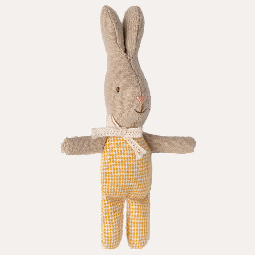 Stuffed rabbit toy with beige top and yellow checkered pants on a white background