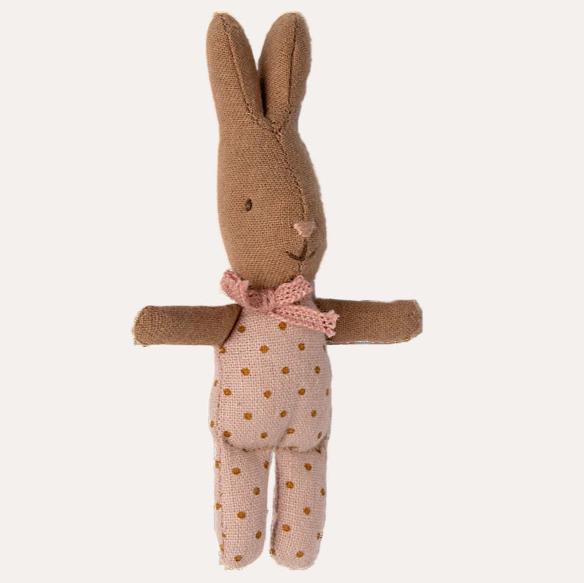 Knitted toy rabbit with a pink bow and polka dot dress on a white background