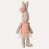 Knitted toy rabbit in a dress with a pom-pom on a white background