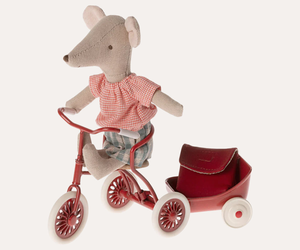 Stuffed mouse toy on a red tricycle with a small red basket on a white background