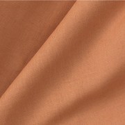 Close-up of Oliver Furniture Mini+ curtain fabric in Caramel, showing folds in the warm brown material.