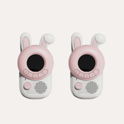 Two The Zoofamily Rabbit walkie-talkies with long white ears, pink face surrounds, round black screens and pale bodies.