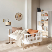 Oliver Furniture Original day bed in White/Oak styled with pale bedding and rust-coloured cushions beside a white shelving unit.