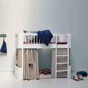 Oliver Furniture white Mini+ low loft bed with pale under-bed curtains, a right-hand ladder and a blue blanket above.