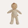 A sleeping doll with a beige fabric head and arms, wearing a cream-colored footed onesie with a small red floral pattern, set against a plain white background.