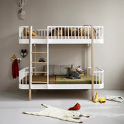 Oliver Furniture Original bunk bed in White/Oak with a left-hand ladder, styled with bedding and cushions in a pale bedroom.