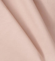 Close-up of Oliver Furniture Classic curtain fabric in Rose, gathered into soft pale pink folds.