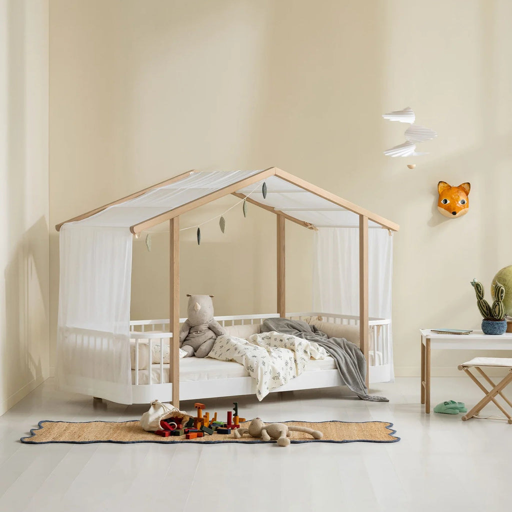 Children's room with a wooden crib, toys, and a fox wall decoration.