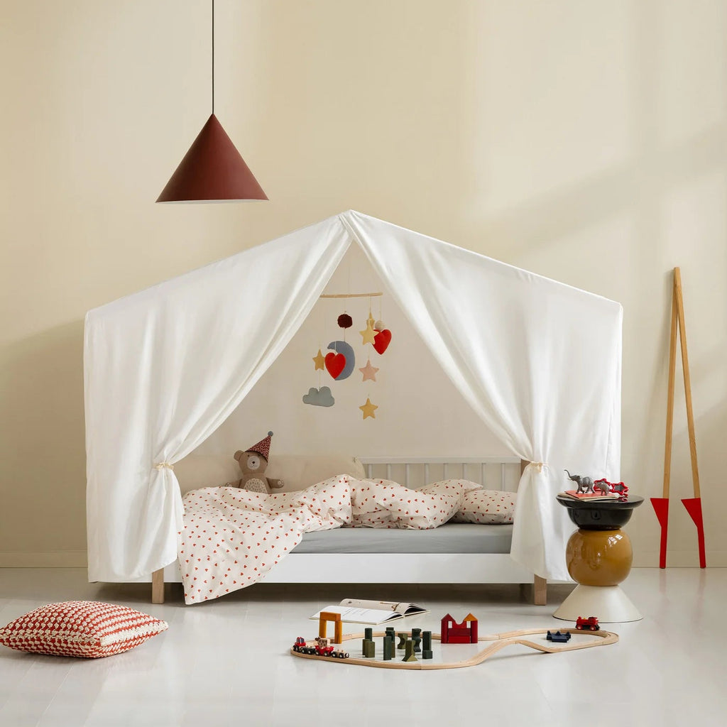 Children's room with a canopy bed, toys, and a pendant light.