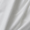 Close-up of white fabric with folds on a white background