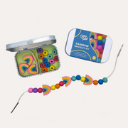 Cotton Twist Rainbow Bracelet Gift Kit with an open tin of colourful beads, its blue lid and a rainbow bead strand.