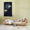 Children's bedroom with a wooden bed, teddy bear, and decorative wall hanging.