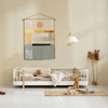 Children's room with a white crib, colorful wall hanging, and wooden toys.