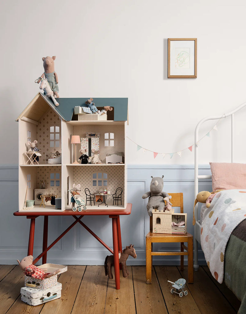 Children's room with a dollhouse, toys, and a bed.