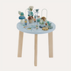 A wooden activity table for children with various playful elements such as wheels, beads, and animal figures set on a round blue tabletop with a natural wood edge.