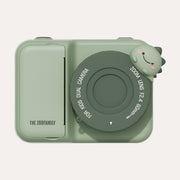 The Zoofamily Dino Zoo Instant Print camera with a pale green body, dark green lens cover and small dinosaur detail.